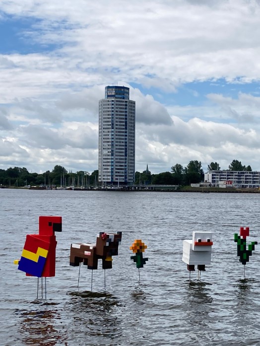 Von Schülern geferigte Kustwerke die Figuren aus dem Spiel Minecraft darstellen sind in der Schlei vor dem Wikingturm in Schleswig im Rahmen der Galerie auf der Schlei zu bewundern.