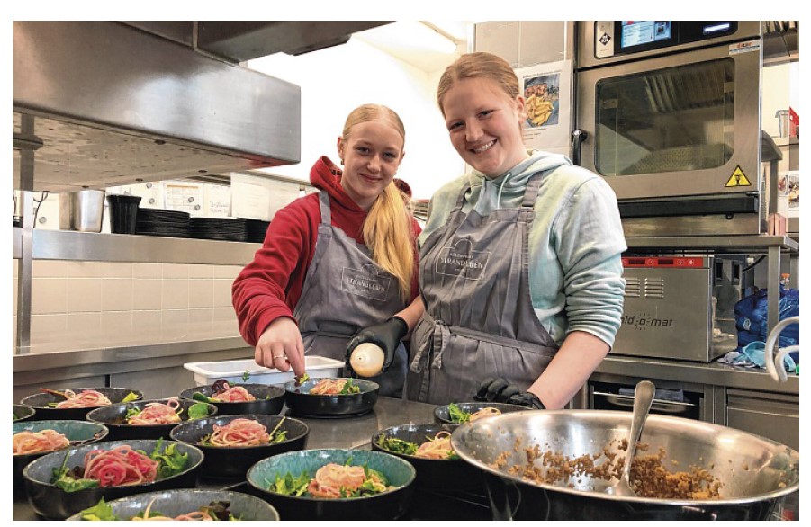 Foto von zwei gut gelaunten Schülerinnen in der Küche des Restaurants "Strandleben" bzgl. des Schülerdinners 20245 der Dannewerkschule Schleswig